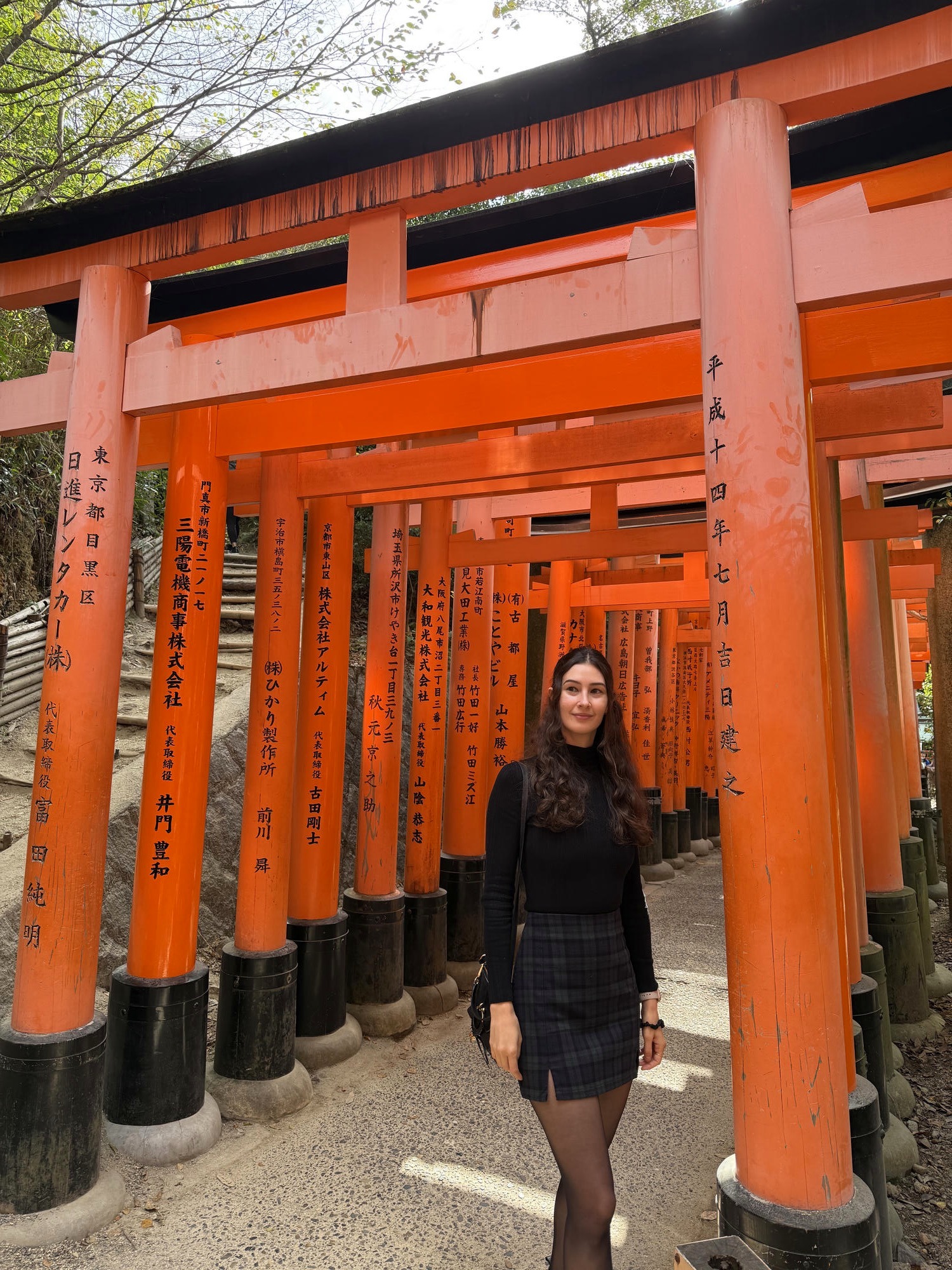 Tassia walking through the orange torii gates at Fushimi Inari in Kyoto